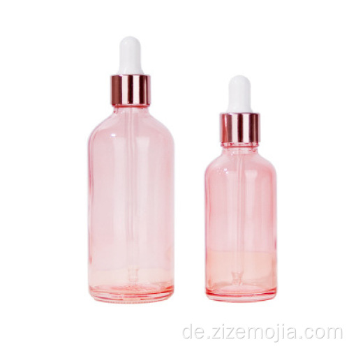 Rosafarbene Tropfflaschen aus Glas mit ätherischen Ölen